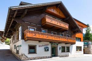 a wooden building with a balcony on top of it at Haus Hubertus in Wagrain