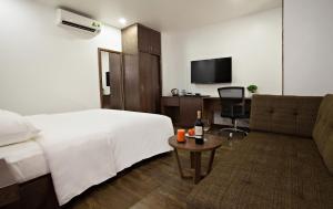a hotel room with a bed and a couch at Inearth Hotel in Hanoi