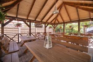 a wooden pavilion with wooden tables and benches at Pensjonat Tadeusz i Apartamenty w Darłówku in Darlowko +110 photos