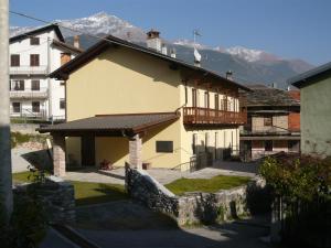 un edificio con balcón y montañas de fondo en AGRITURISMO Cré Seren, en Susa