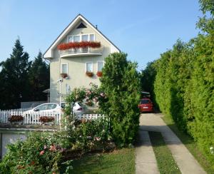 a white house with a white fence and flowers at Ida Panzió in Budapest