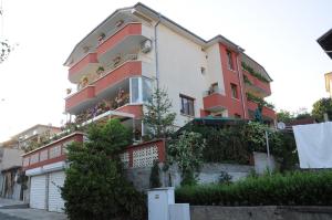 a red and white building with plants on it at Hotel Babeva in Sveti Vlas