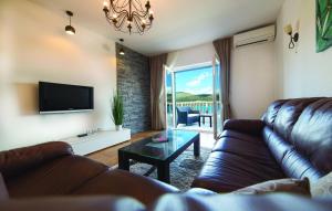 ein Wohnzimmer mit einem Ledersofa und einem TV in der Unterkunft Villa Calluna in Trogir