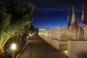 a building with flags on the side of it at night at Garden Hotel Ripa in Vieste