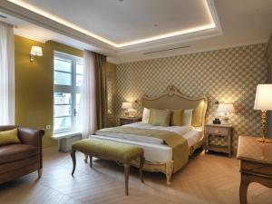 a bedroom with a bed and a chair and a window at Relais Le Chevalier in Riga