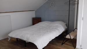 シャンブルトーにあるL'Atelier du Tailleur à 5 mn du Puy du Fouの椅子付きの客室の白いベッド1台