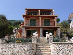 una grande casa con scale e un muro di pietra di Villa Pepy a Mesongi