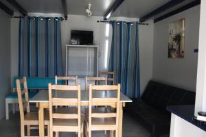 a dining room with a table and chairs and a couch at Torreira Camping & Bungalows in Torreira