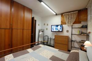 1 dormitorio con 1 cama, vestidor y TV en Casa Mareblù, en SantʼAndrea