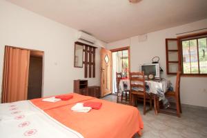 a bedroom with two beds and a table and a television at Robinson Braco in Bogomolje