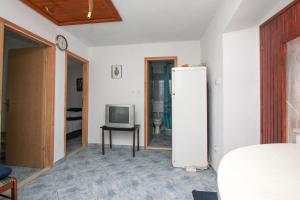 a living room with a refrigerator and a tv at Robinson Braco in Bogomolje