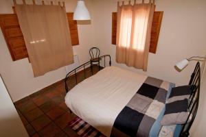 een slaapkamer met een bed in een kamer met ramen bij El mirador del norte in Cortez de Pallas