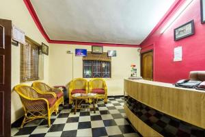 a waiting room with yellow chairs and red walls at MC Resort Wildlife Resort Bandipur in Bandipūr