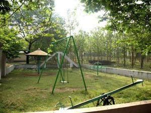 un parque infantil con columpios en MC Resort Wildlife Resort Bandipur, en Bandipūr