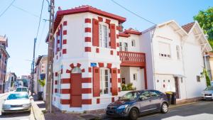 un bâtiment rouge et blanc sur le côté d'une rue dans l'établissement CAP BERILOU . Qualité et Confort Assuré ., à Arcachon