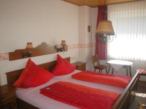 ein Schlafzimmer mit zwei roten Kissen auf einem Bett in der Unterkunft Haus am Stryckweg in Willingen