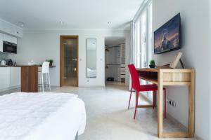 Villa Velvet في فيلنوف لوبيه: غرفة نوم مع سرير ومكتب مع كرسي احمر