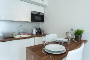 a kitchen with a table with plates and wine glasses at Villa Velvet in Villeneuve-Loubet
