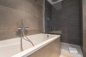 a bathroom with a bath tub and a shower at Villa Velvet in Villeneuve-Loubet