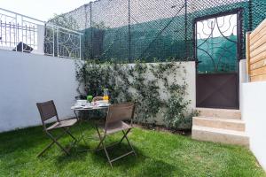 a table and chairs on the grass in a backyard at Villa Velvet in Villeneuve-Loubet