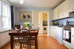 a kitchen with a wooden table and chairs in a kitchen at Shelduck Cottage in Feorlean