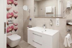 a bathroom with a sink and a toilet and a mirror at Hotel Engelbert in Iserlohn