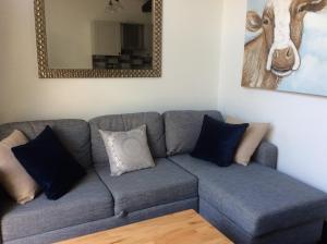 a blue couch with pillows in a living room at No1 The Smithy in Tattenhall