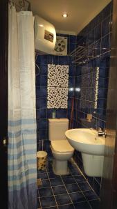 La salle de bains est pourvue de carrelage bleu, de toilettes et d'un lavabo. dans l'établissement بورتو مطروح Porto Matrouh for Family, à Marsa Matruh