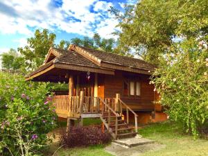 een klein houten huis met een veranda en een terras bij Romantic Time Mountain Resort in Pai
