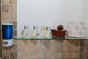 a glass shelf in a bathroom with a drink at Fiumicino Inn Airport in Fiumicino