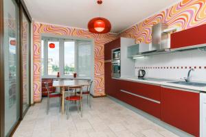 una cocina con armarios rojos y una mesa con sillas. en Two-storey apartment near IEC en Kiev