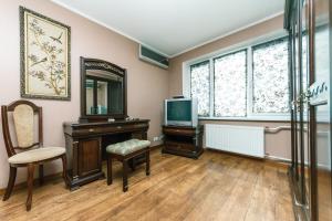 a room with a tv and a desk and a mirror at Apartment on Cheliabinska 19 in Kyiv