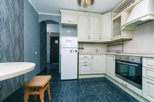 a kitchen with white cabinets and a white refrigerator at Apartment on Cheliabinska 19 in Kyiv