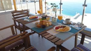 a table with breakfast foods and orange juice on it at Anna Apartments in Sarandë