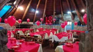 Agriturismo Su Pinnettu في فوني: غرفة بها طاولات حمراء وبالونات على الأسقف