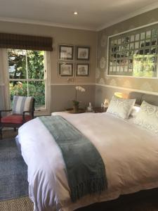 1 dormitorio con 1 cama grande y 1 silla en Maison Jacaranda, en Johannesburgo