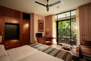 
a hotel room with a bed and a tv at Heritance Kandalama in Sigiriya
