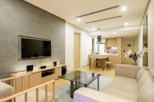 188 Suites by NamaStay في كوالالمبور: غرفة معيشة مع أريكة وتلفزيون