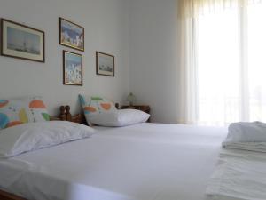 1 dormitorio blanco con 2 camas y ventana en Mary's Apartments, en Chrani