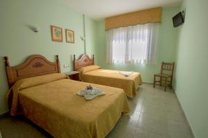 A bed or beds in a room at Hostal O Camouco