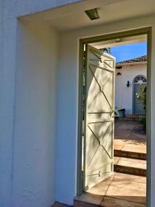una puerta abierta a una casa con porche en Maison Jacaranda, en Johannesburgo