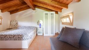 1 dormitorio con 1 cama y 1 sofá en B&B Nido Sui Laghi, en San Donnino della Nizzola