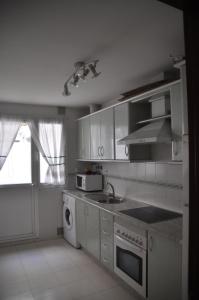 a white kitchen with a sink and a stove at Mirador de Santiago in Sanlúcar de Barrameda