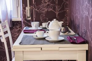 una mesa con tazas y platillos. en Gagliardi House en Tor Vergata