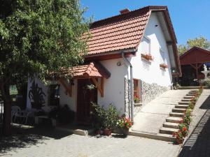 una pequeña casa blanca con techo rojo en Agávé Apartman, en Sárvár