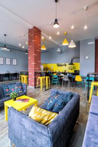 a living room with blue couches and tables and yellow accents at Hostel Nikolskiy in Yekaterinburg
