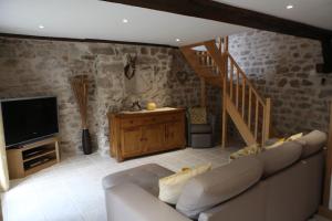 ein Wohnzimmer mit einem Sofa und einem TV in der Unterkunft Castle Terrace in Faux-la-Montagne