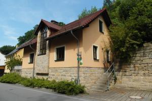una casa gialla con muro di mattoni e scale di Haus Ferienromantik a Pirna