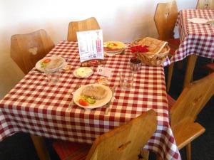 a red and white checkered table with plates of food on it at Erika penzión in Vysoke Tatry - Tatranska Lesna