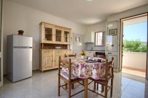 una cucina con tavolo e frigorifero di Dolce Mimì a Marina di Pescoluse